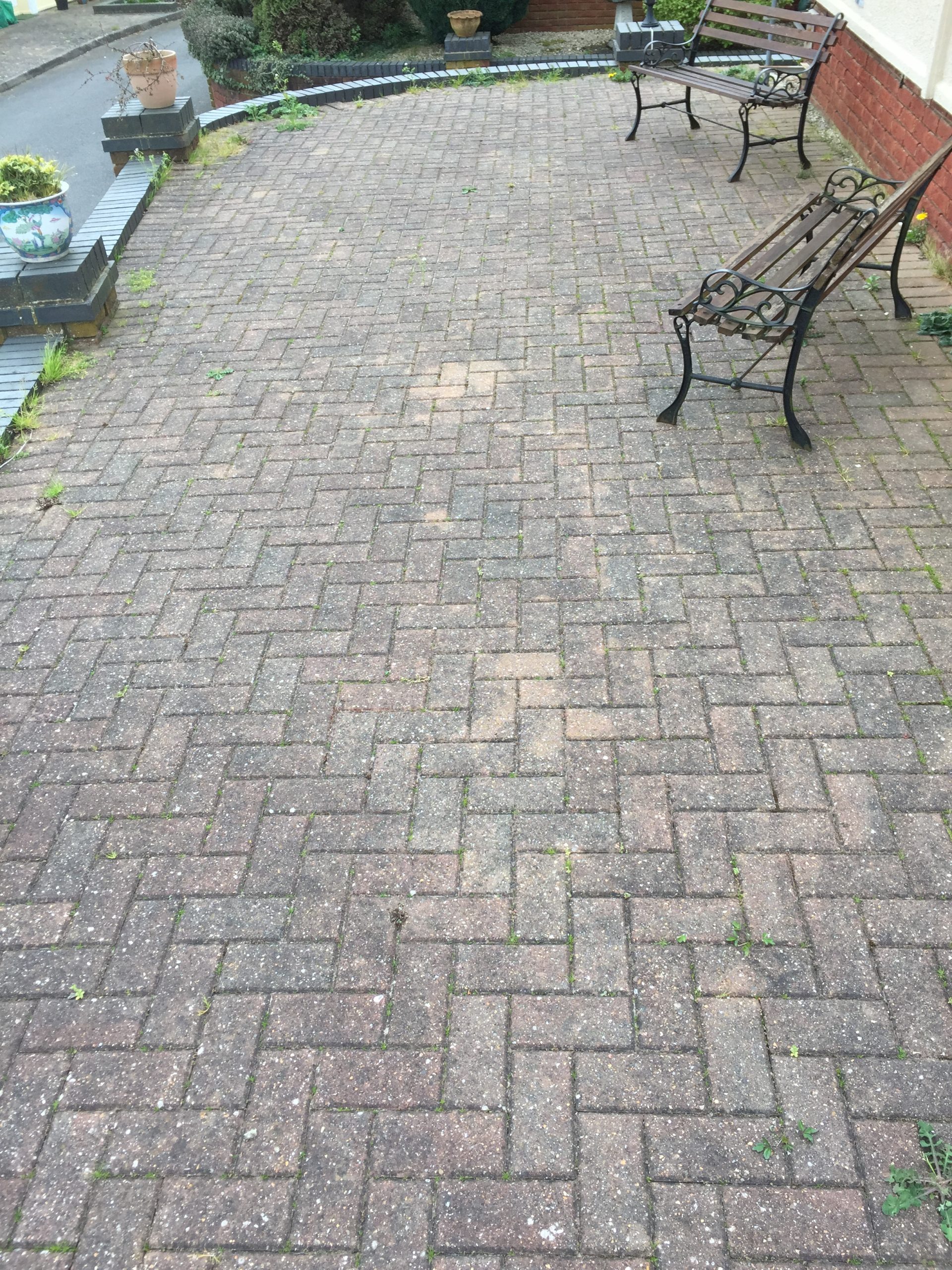Dirty herringbone block paved driveway before cleaning